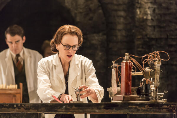 actors on stage dressed in lab coats