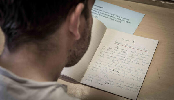 man reading book with handwritten story