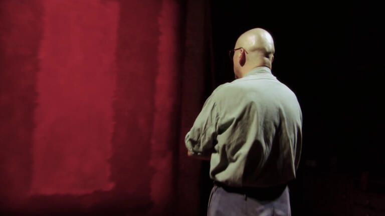 actor in front of a red painting