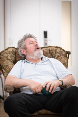 older man seated in armchair