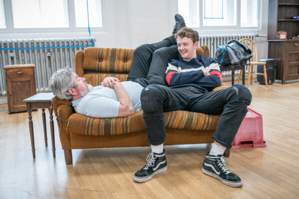 two men relaxing on sofa