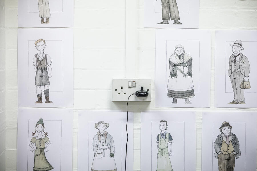 theatre costume design sketches stuck on a wall